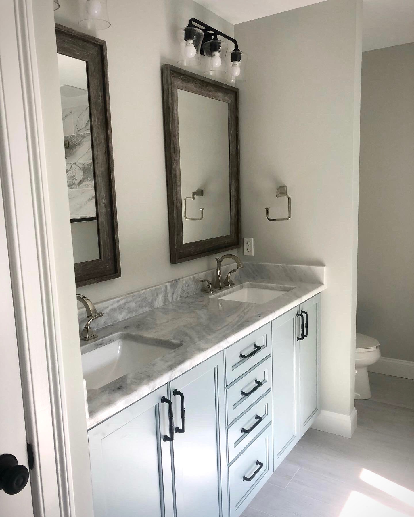 Side by Side Vanity Mirrors with Cabinets and Separated Toilet